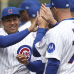 Moisés Ballesteros, de los Cachorros de Chicago, saluda a sus compañeros de equipo en el Wrigley Field.