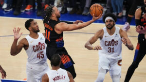 Jalen Brunson (11), de los New York Knicks, se abre paso entre Donovan Mitchell (45), Evan Mobley (4) y Jarrett Allen (31), de los Cleveland Cavaliers